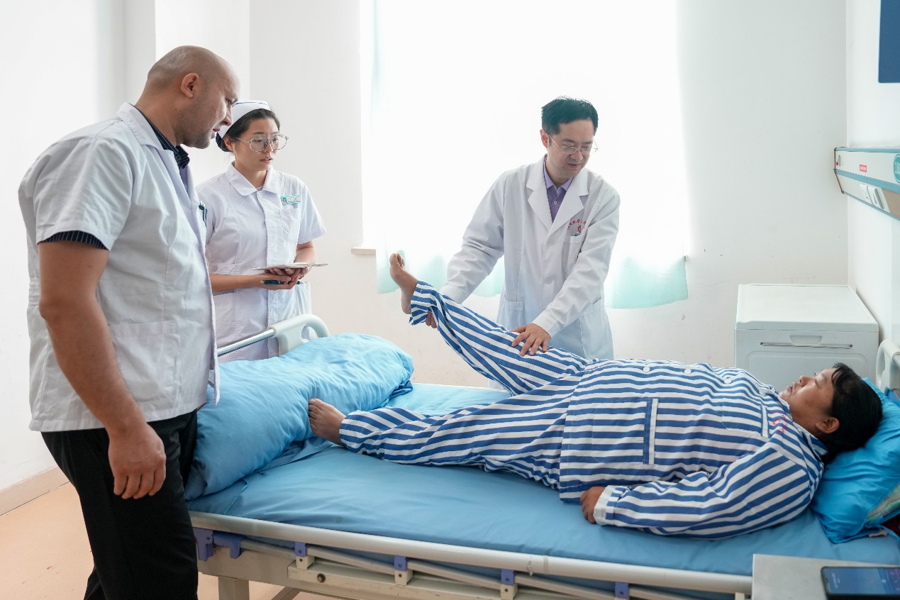 在和田地區人民醫院掛職骨科副主任的北京積水潭醫院脊柱外科副主任醫師於傑(右一),在進行教學查房,講解腰椎間盤突出症患者體格檢查要點,並為該患者即將進行的腰椎微創手術進行方案設計和術前準備。 在和田地區人民醫院掛職骨科副主任的北京積水潭醫院脊柱外科副主任醫師於傑(右一),在進行教學查房,講解腰椎間盤突出症患者體格檢查要點,並為該患者即將進行的腰椎微創手術進行方案設計和術前準備。