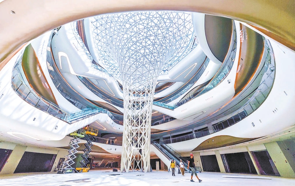 7月16日，灣裏·王府井WellTown奧萊綜合體內，中庭高聳的馬蹄蓮造型裝置已初見雛形。