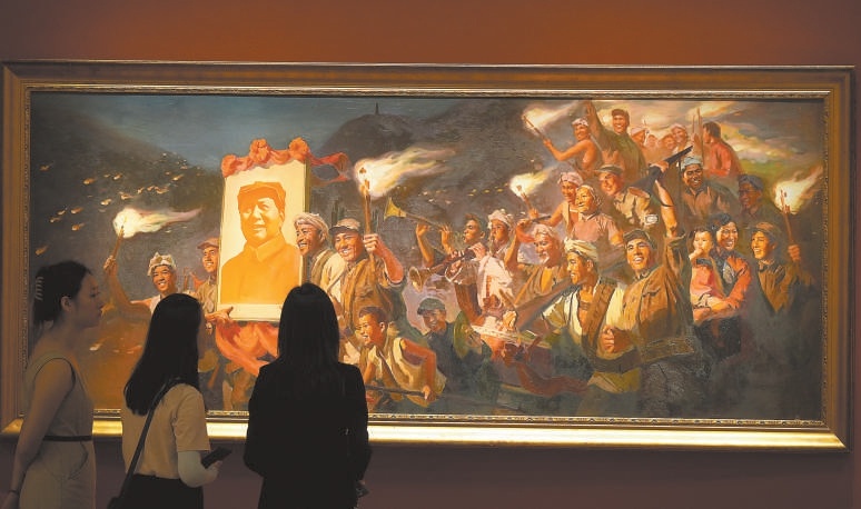 參觀者欣賞油畫《延安的火炬》。這幅畫描繪了1945年日本投降後，夜幕下延安軍民舞動火炬、慶祝勝利的場景。