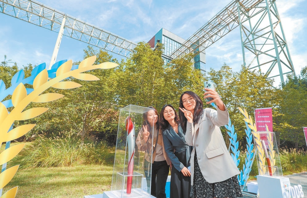 圖為在冬奧精神主題展上，遊客和冬奧會火炬合影。