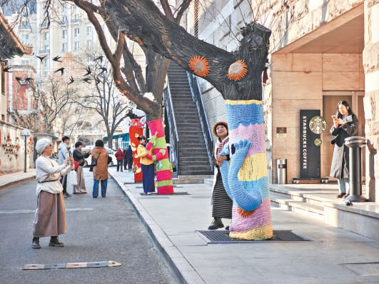 降雪前，東城區紅星胡同的大樹穿上“毛衣”，市民紛紛打卡。