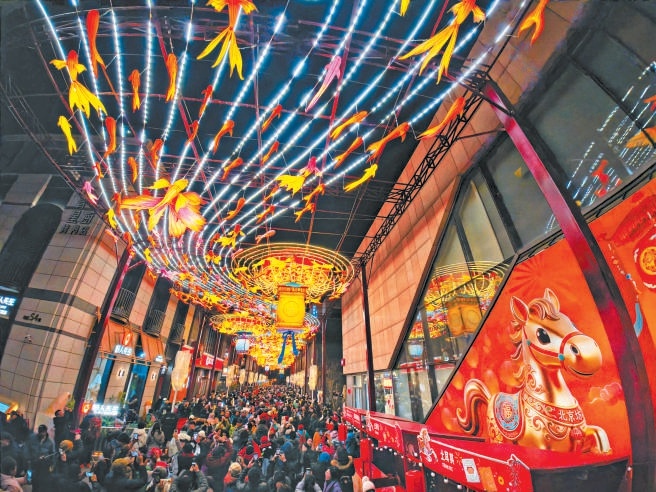 除夕夜，北京坊張燈結彩，年味濃鬱。巨型彩繪馬年主題球高懸街巷，絢麗花燈如星河垂落。市民遊客賞燈漫步，在傳統非遺與新潮年味的交融中，感受京城新春的獨特魅力。