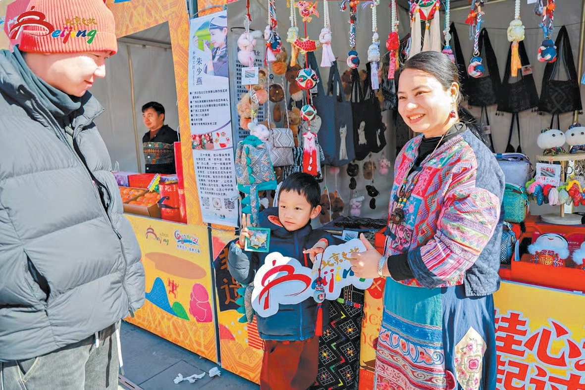 朝外商圈廟會展位上，身著民族服裝的工作人員向遊客介紹廣西特色手工藝品。