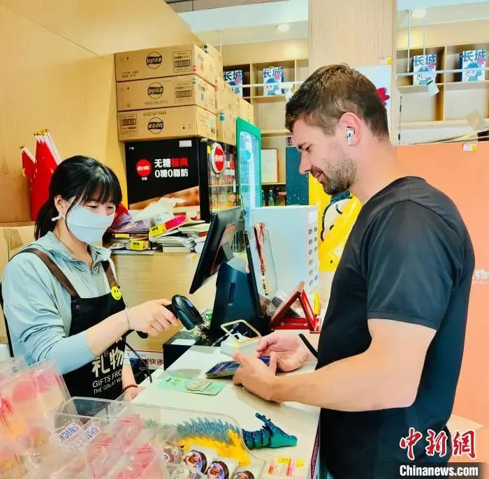 圖為外籍遊客在北京八達嶺長城景區商店內體驗電子支付。