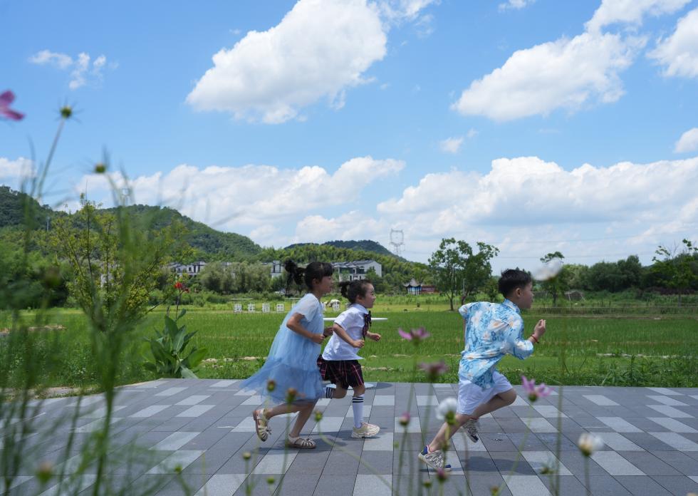 兒童在餘姚市梁弄鎮的田野間奔跑（7月3日攝）。