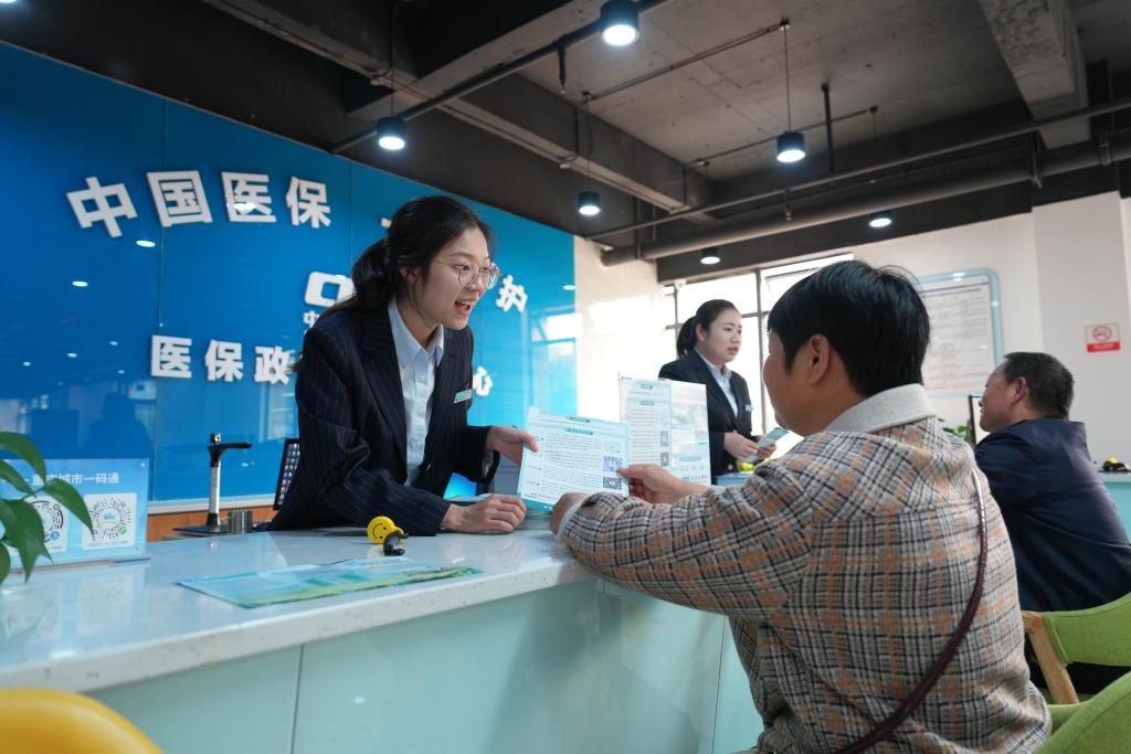 2023年11月1日，在重慶市北碚區歇馬街道醫保政務服務分中心，工作人員給居民講解醫保政策。