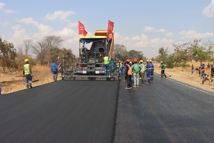 2024年8月27日，在馬拉維恩科塔科塔，施工人員在卡帕滕加至本加公路升級改造項目路段鋪築瀝青路麵。