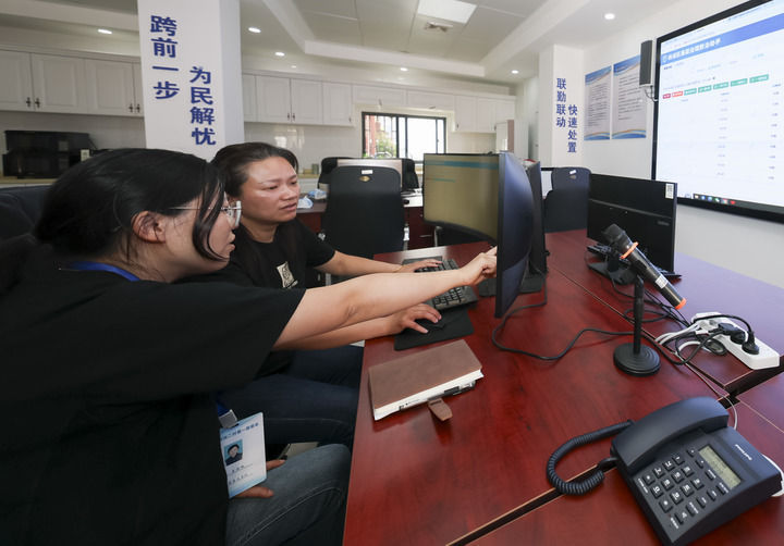 2025年5月12日，在上海市楊浦區殷行街道第五綜合網格工作站，工作人員討論通過“一鍵呼叫”與居民溝通。