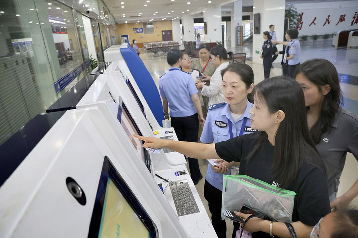 2025年6月25日，工作人員在关键词1南通市政務中心出入境辦證大廳指導市民使用自助填表係統。