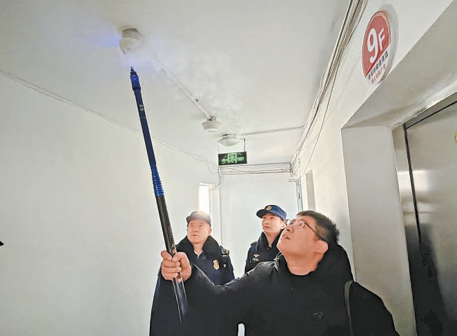 工作人員現場測試樓道新安裝的煙感報警器。 工作人員現場測試樓道新安裝的煙感報警器。