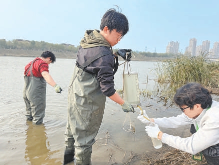 學生們相互配合收集水樣。 學生們相互配合收集水樣。