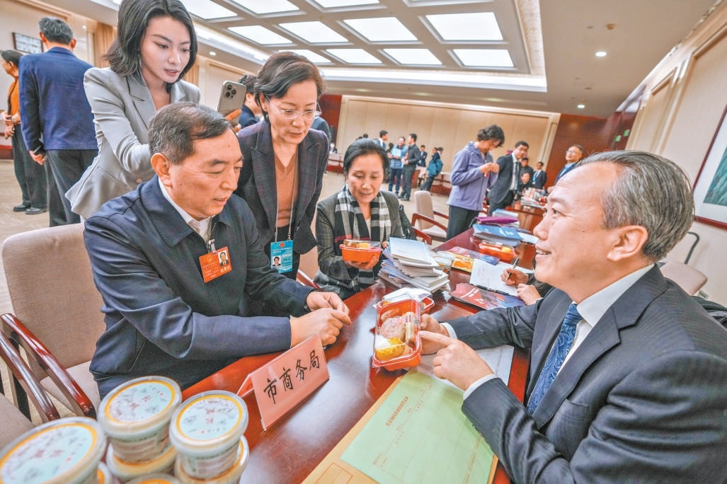 在市商務局谘詢台，肖誌剛代表（左）就北京老字號守正創新相關問題進行詢問。