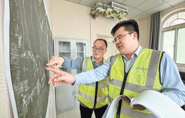 1月31日，劉太訓（右）和同事正在研究施工方案。