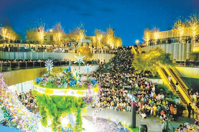 夜色下，顧客在萬象匯觀看演出。（資料圖）