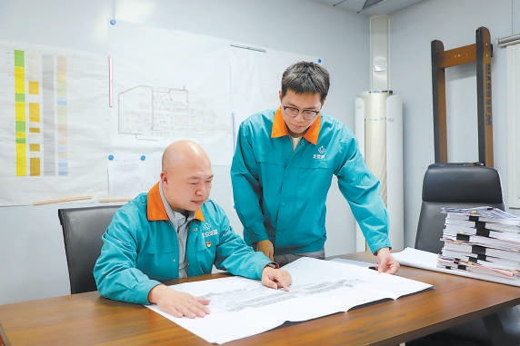 廖陳斌（左）和王思聰一起看項目圖紙。