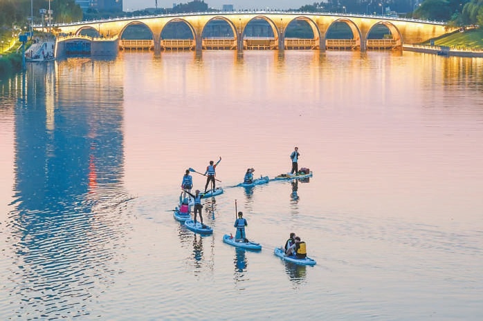 北運河上玩槳板的年輕人。